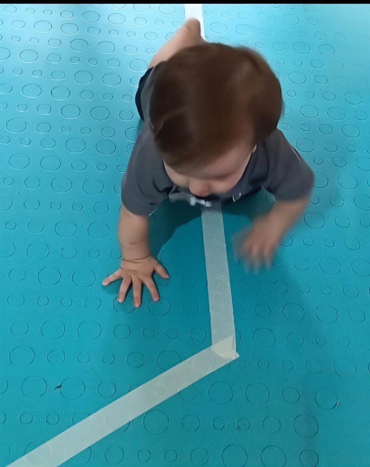 Bebé explorando superficies sensoriales durante gateo dirigido