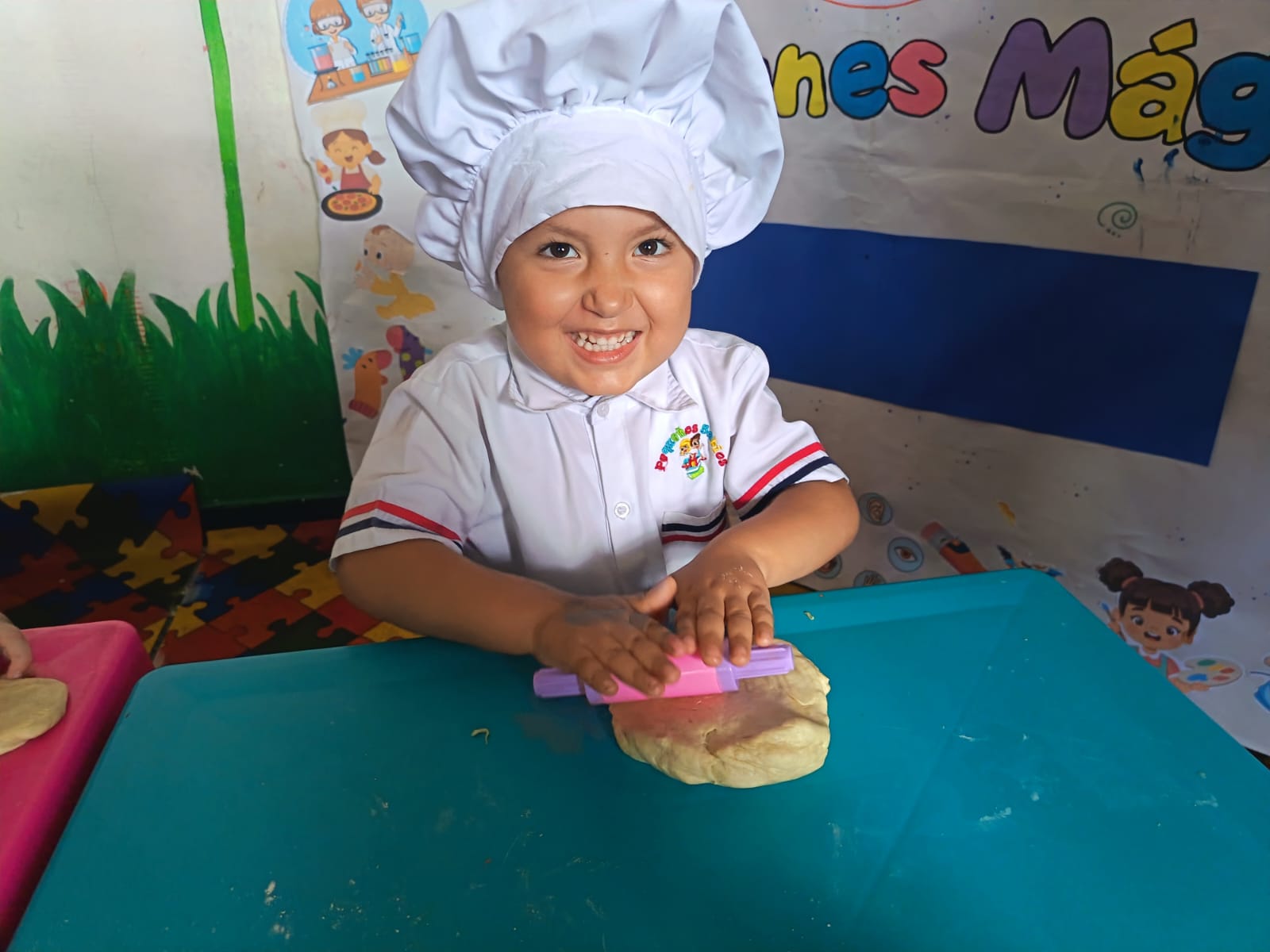 Niña sonriente con gorro de chef aprendiendo a cocinar