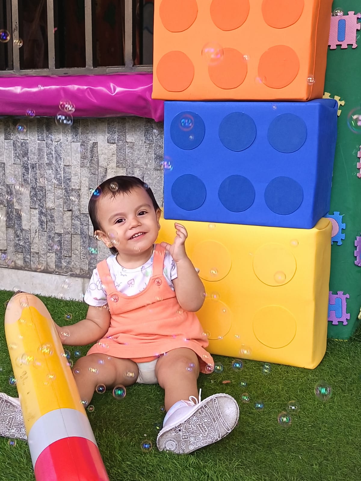 Niña pequeña jugando con bloques grandes de colores y burbujas