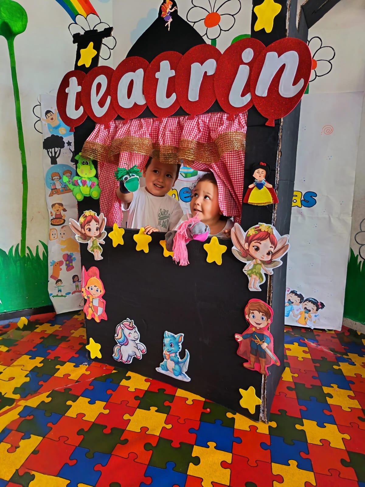 Niños presentando obra de títeres en el teatrín del jardín