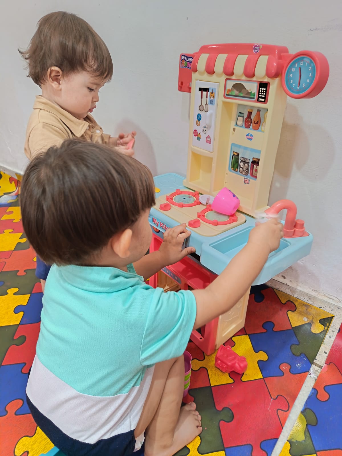 Niños jugando con cocina de juguete en juego de roles