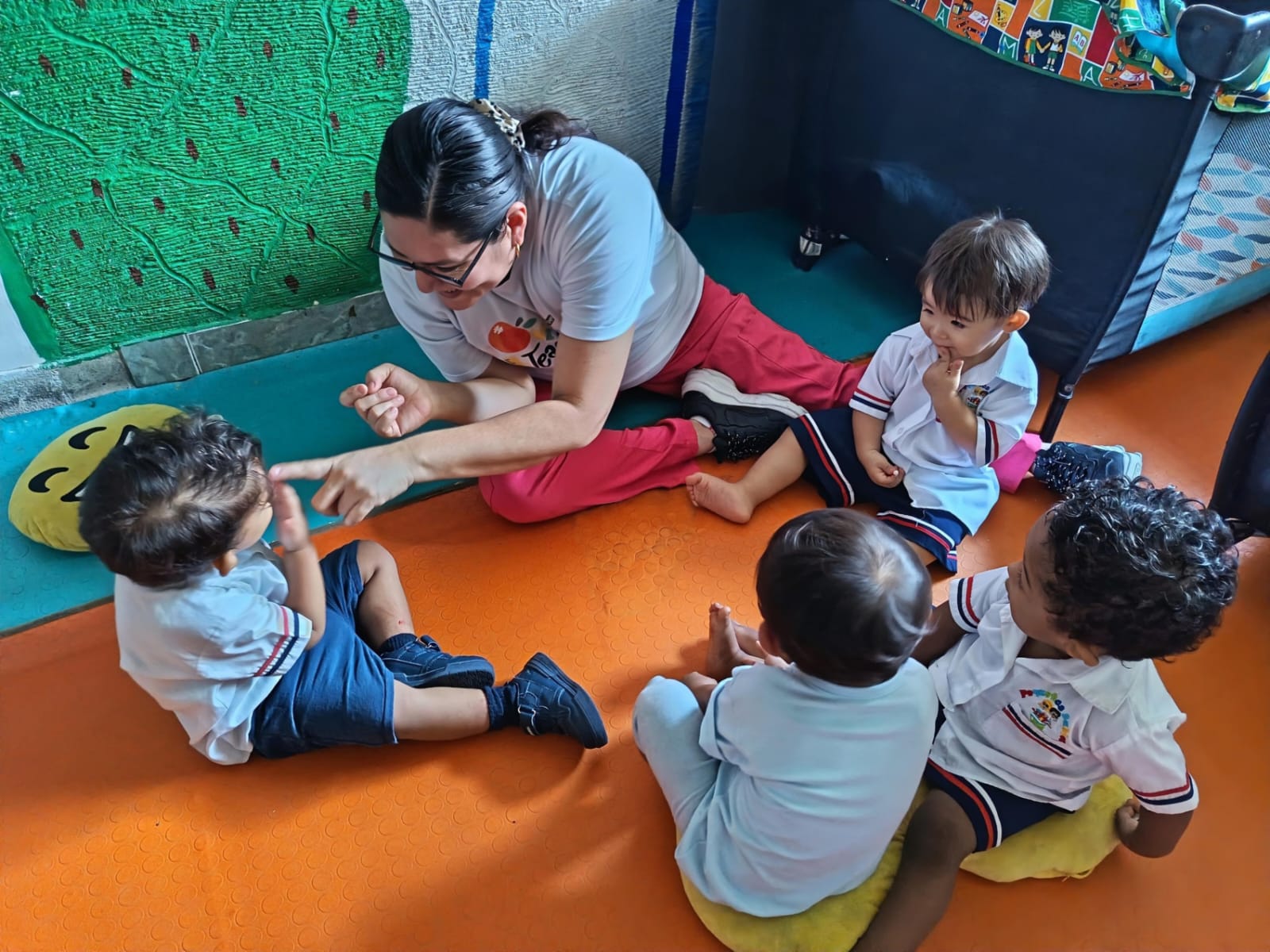 Profesora trabajando con grupo pequeño de niños en actividad pedagógica