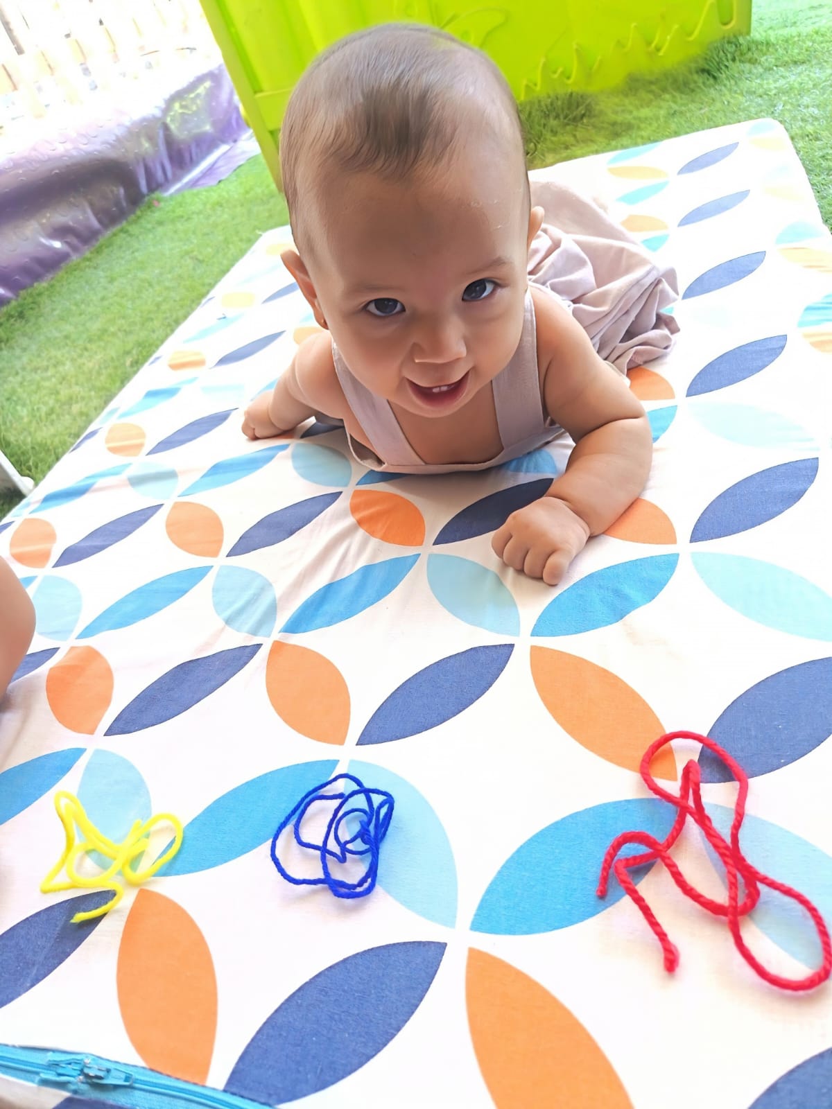 Bebé explorando materiales sensoriales en tapete de estimulación