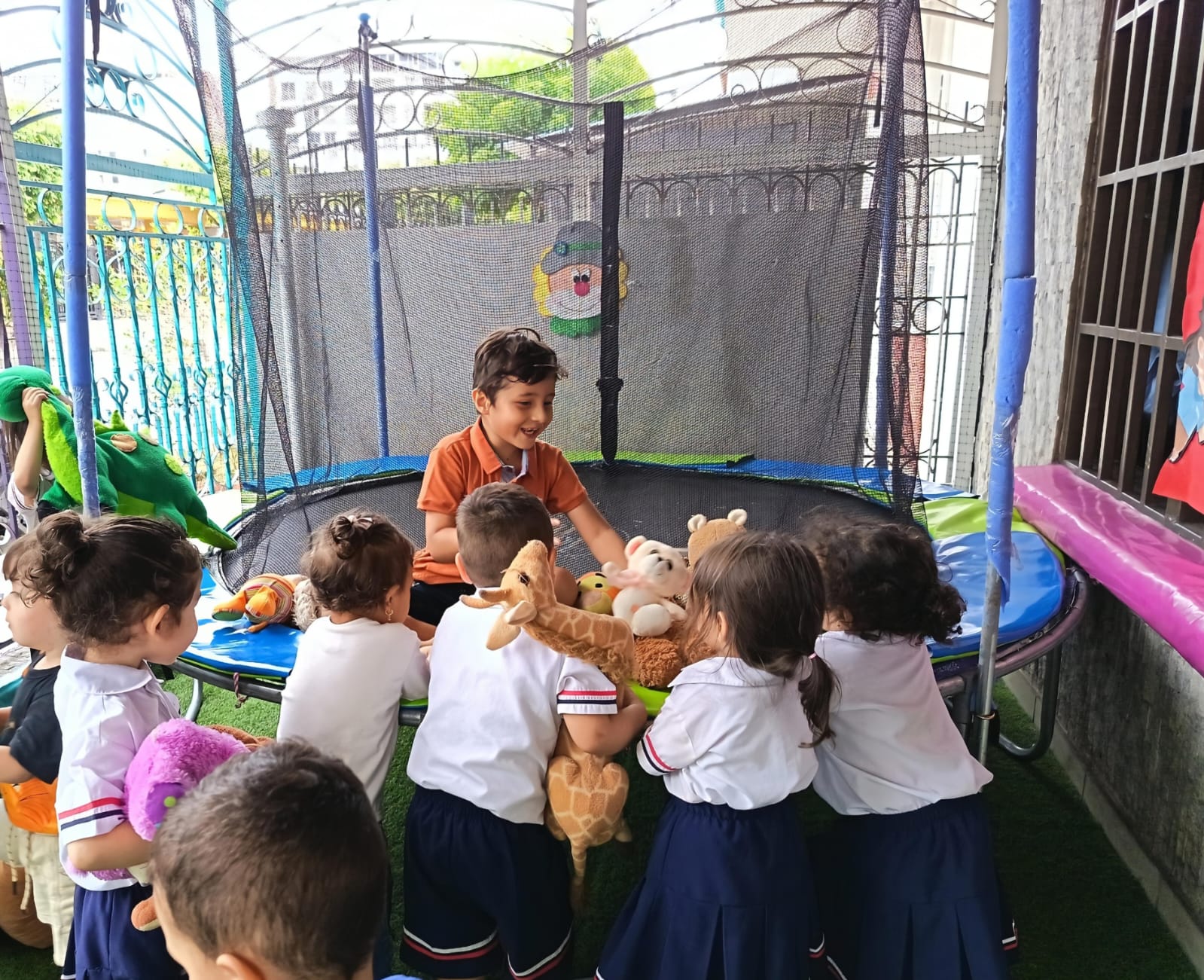Niños disfrutando de juegos en trampolín en instalaciones seguras del jardín